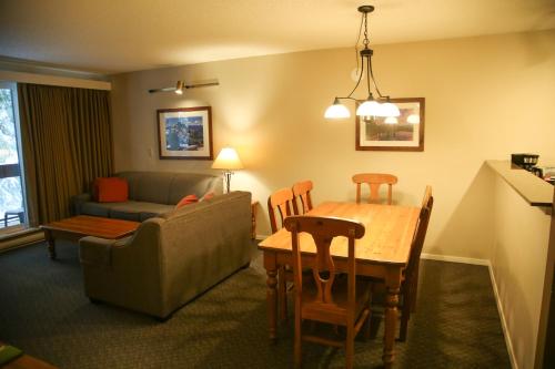 a living room with a couch and a table and chairs at Tantalus Lodge by Elevate Vacations in Whistler
