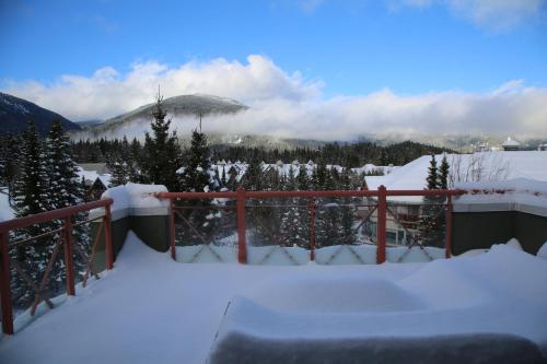 a snow covered balcony with a view of a mountain at Alpenglow Lodge by Elevate Vacations in Whistler