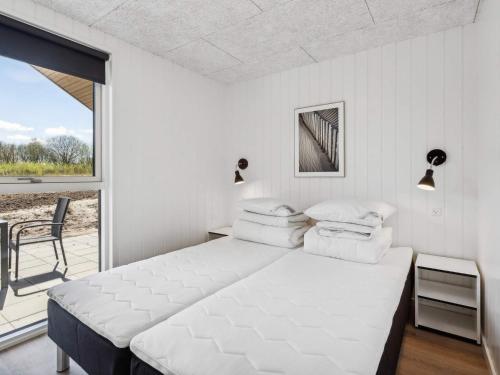 5 star holiday home in Sydals في Sarup: غرفة نوم بيضاء مع سرير وشرفة