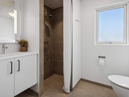 5 star holiday home in Sydals في Sarup: حمام أبيض مع دش ومغسلة