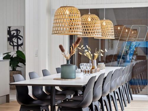 a dining room table with chairs and pendant lights at 5 star holiday home in Otterup in Otterup