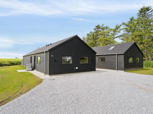 a black house with a garage on a driveway at 5 star holiday home in Otterup in Otterup