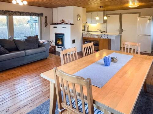 a kitchen and living room with a wooden table and chairs at 4 person holiday home in FÄRJESTADEN in Färjestaden