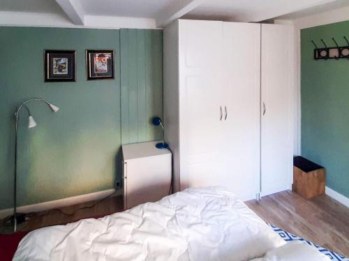 a bedroom with a white bed and a green wall at 9 person holiday home in mandal in Mandal