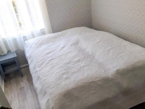 a bed with a white comforter in a bedroom at 9 person holiday home in mandal in Mandal