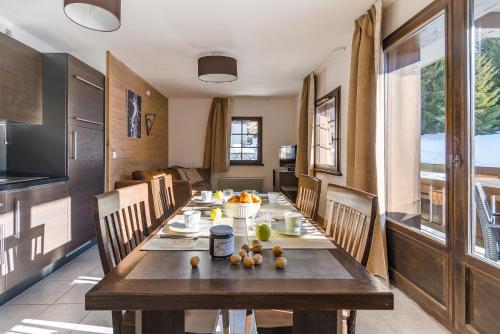 a dining room with a long wooden table and chairs at Lagrange Vacances Les Fermes Emiguy in Les Gets