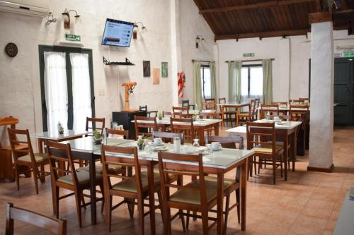 a restaurant with tables and chairs in a room at Posada Las Camelias in Estancia La Totoro South