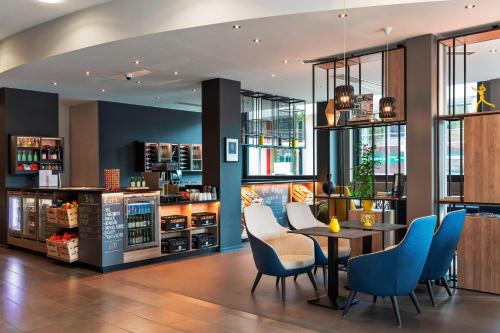 a restaurant with blue chairs and a table at Courtyard by Marriott Zurich North in Zürich
