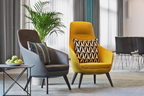 two chairs and a table in a living room at Courtyard by Marriott Zurich North in Zürich