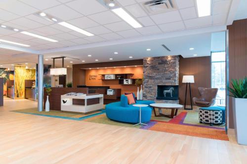 a lobby with a blue couch and a fireplace at Fairfield Inn & Suites by Marriott Medina in Medina