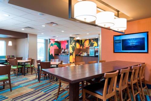 a dining room with a large wooden table and chairs at Fairfield Inn & Suites by Marriott Medina in Medina