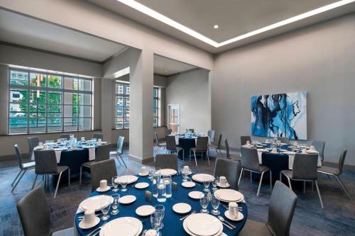 a conference room with tables and chairs and a painting at Delta Hotels by Marriott Richmond Downtown in Richmond
