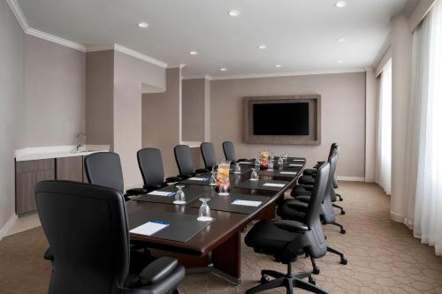 a conference room with a long table and black chairs at Delta Hotels by Marriott Richmond Downtown in Richmond