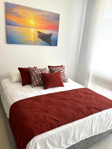 ein Schlafzimmer mit einem großen Bett mit einem Gemälde an der Wand in der Unterkunft Cartagena-Acogedor MorrosEOS Salida directa al mar in Cartagena de Indias