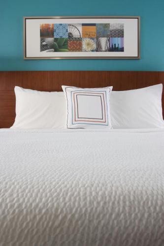 a bed with white sheets and pillows in a bedroom at Fairfield Inn Charlotte Gastonia in Gastonia