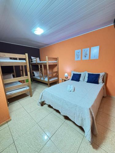 a bedroom with a bed and two bunk beds at Pousada Recanto dos Maximianos in Jarinu
