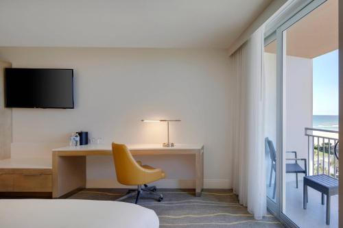 a hotel room with a desk and a yellow chair at Delta Hotels by Marriott Daytona Beach Oceanfront in Daytona Beach