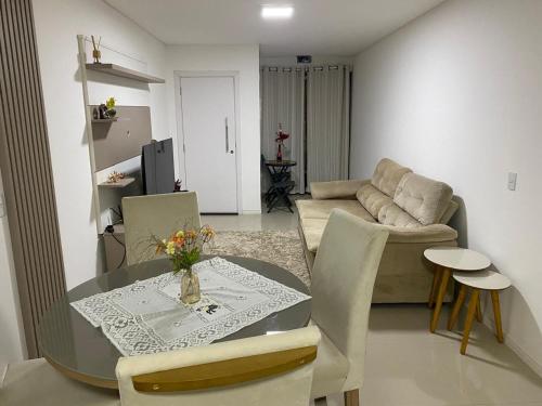 een woonkamer met een tafel en een bank bij Apartamento Santa Clara in Balneário Camboriú