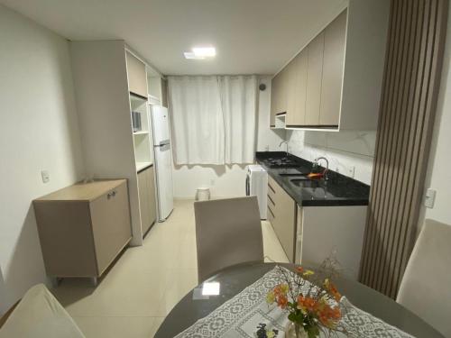 een kleine keuken met een tafel en een eetkamer bij Apartamento Santa Clara in Balneário Camboriú