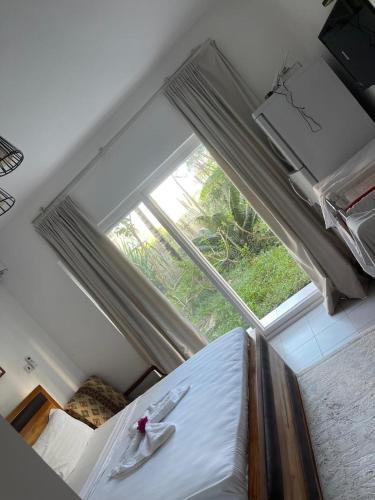 a bedroom with a bed and a large window at Mama's Studio Apartment in Zanzibar City