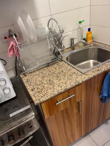 a kitchen counter with a sink and a stove at Mama's Studio Apartment in Zanzibar City