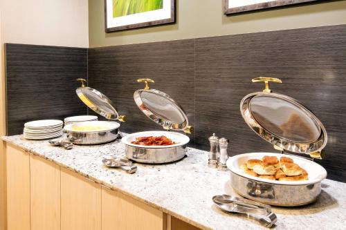 a kitchen with three pans of food on a counter at Fairfield Inn & Suites by Marriott Charlotte Uptown in Charlotte