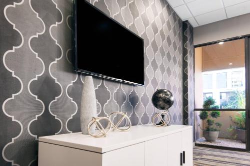 a living room with a tv on a wall at Fairfield Inn & Suites by Marriott Charlotte Uptown in Charlotte