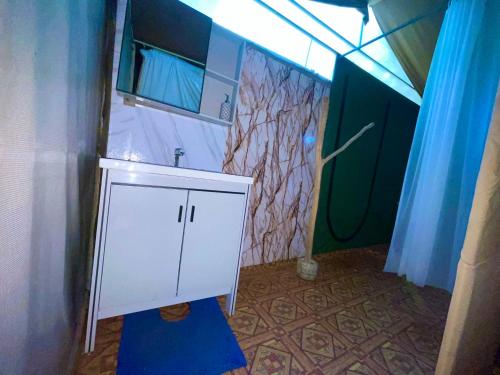 a bathroom with a white sink and a mirror at Yala Podi Hoona Bush Camp in Yala