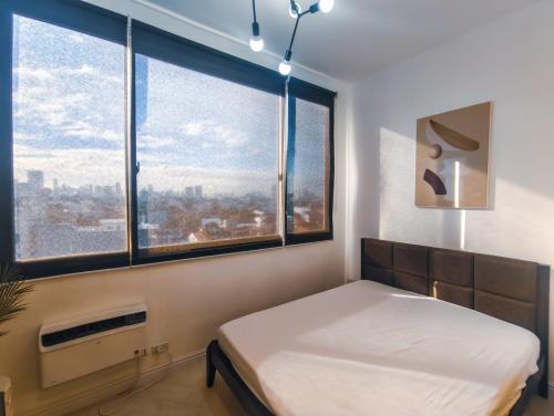 a bedroom with a bed and a large window at Voss Condominium in Manila