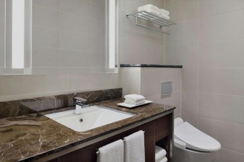 a bathroom with a sink and a toilet at Delta Hotels by Marriott City Center Doha in Doha