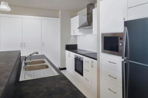 a kitchen with a sink and a refrigerator at Delta Hotels by Marriott City Center Doha in Doha