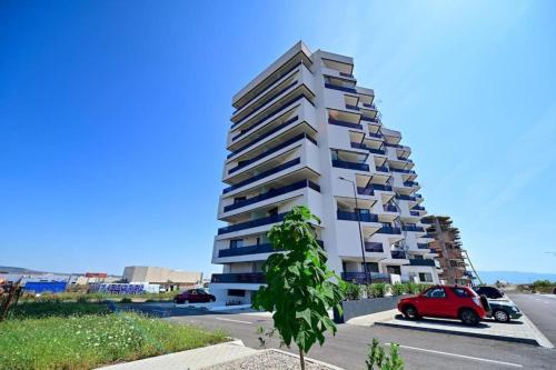 a building with a red car parked in front of it at EVO Apartament de Lux André in Sibiu