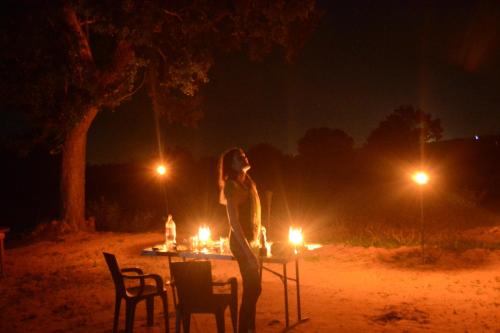 a woman standing on a table at night at Yala Podi Hoona Bush Camp in Yala