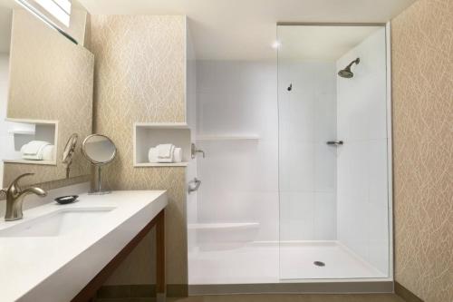 a white bathroom with a shower and a sink at Courtyard by Marriott Toronto Mississauga/West in Mississauga
