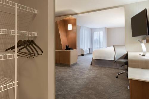a hotel room with a bed and a desk and a bedroom at Courtyard by Marriott Toronto Mississauga/West in Mississauga
