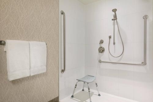 a bathroom with a shower with a stool in it at Courtyard by Marriott Toronto Mississauga/West in Mississauga