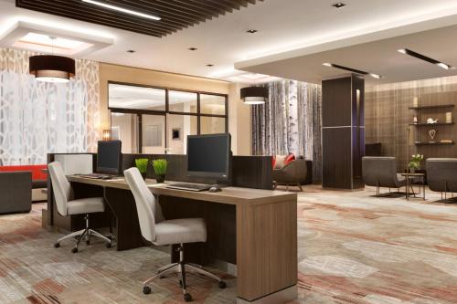 an office with a desk with two monitors and chairs at Courtyard by Marriott Toronto Mississauga/West in Mississauga