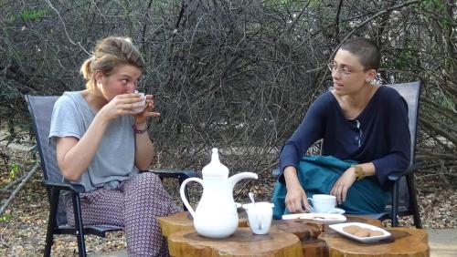 two women sitting in chairs at a table with a tea pot at Yala Podi Hoona Bush Camp in Yala