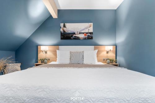 a bedroom with a large bed with blue walls at Ferienwohnung Bude 14 Dagebüll in Dagebüll