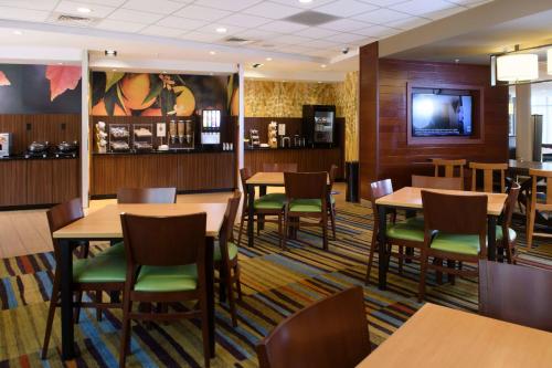 a dining room with tables and chairs and a tv at Fairfield Inn & Suites by Marriott Richmond Ashland in Ashland