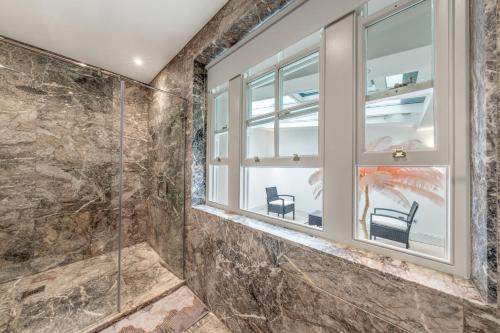 a bathroom with a window and two chairs at 250 SqM MEGA MANSION in London