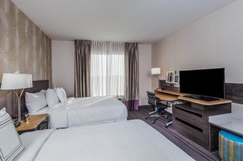 a hotel room with two beds and a desk with a television at Fairfield Inn & Suites by Marriott Chicago Schaumburg in Schaumburg