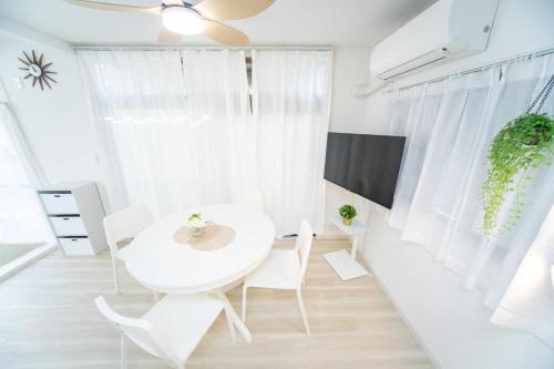 a white dining room with a white table and chairs at Miraie Yokkaichi Nishishinchi 2 in Yokkaichi