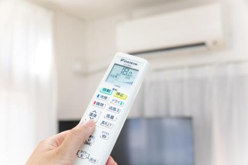 a person holding a remote control in their hand at Miraie Yokkaichi Nishishinchi 2 in Yokkaichi