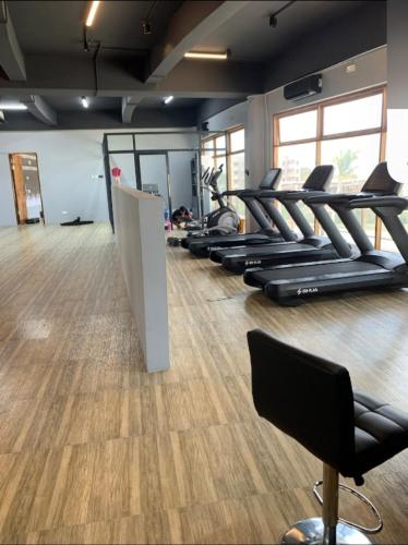 a gym with a row of treadmills at Rest Studio Apartment in Dambani