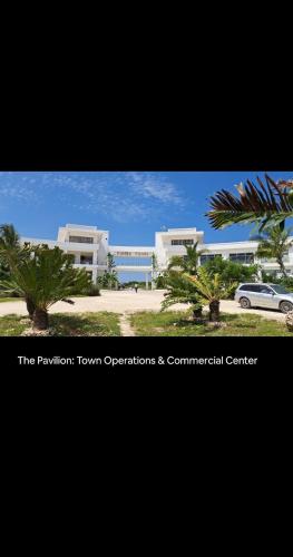 a view of a building with palm trees and a car at Rest Studio Apartment in Dambani