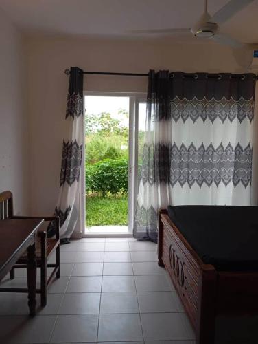 a room with a bed and a sliding glass door at Rest Studio Apartment in Dambani