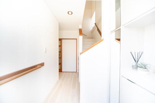 a hallway of a house with white walls and wood floors at Miraie Yokkaichi Nishishinchi 2 in Yokkaichi