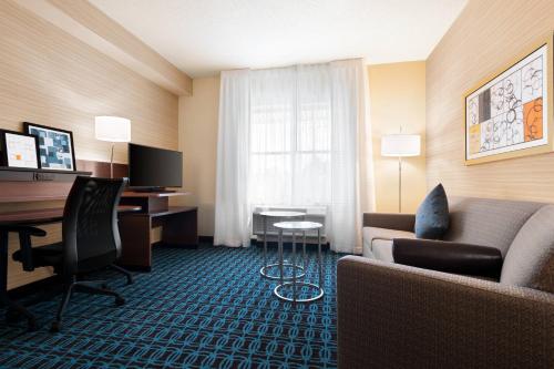 a hotel room with a couch and a desk at Fairfield Inn & Suites by Marriott Charlottesville Downtown/University Area in Charlottesville