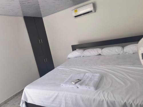 a bed with a towel and a remote control on it at Villas Campestres las Heliconias in Villavicencio